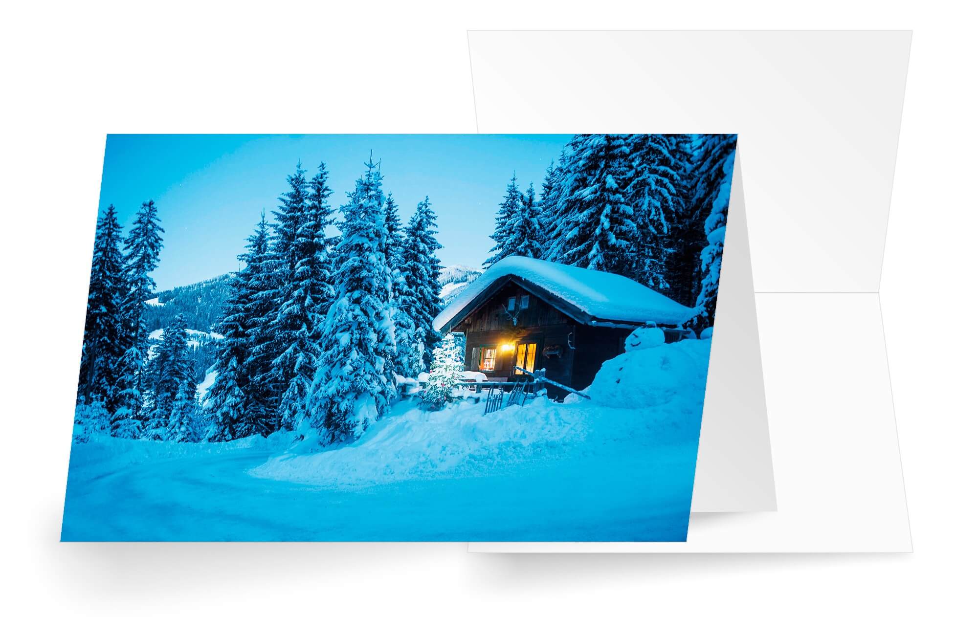 Idyllische Weihnachtskarte mit verschneiter Berghütte und Tannenwald am Berg