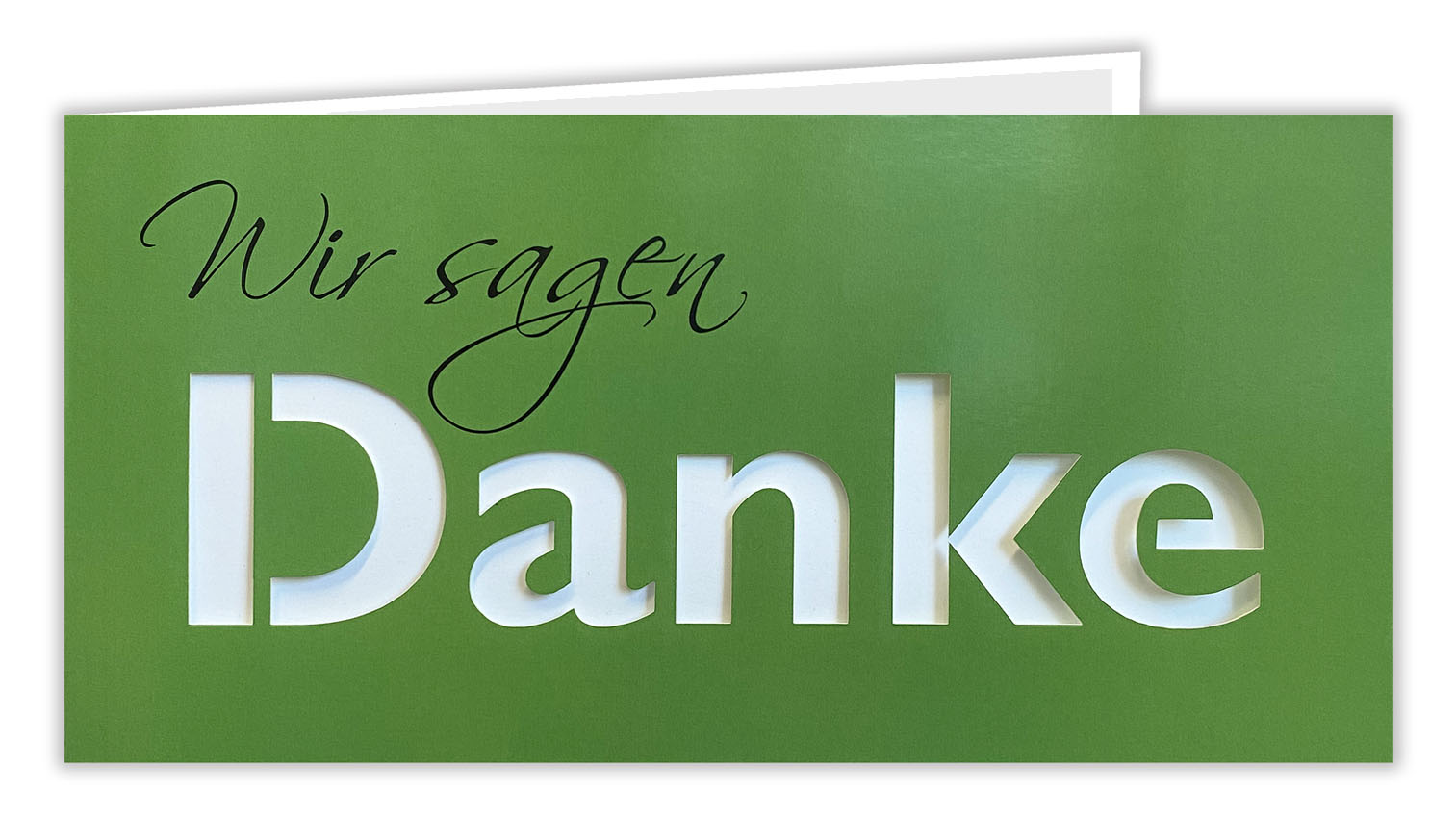 Grüne Dankkarte DIN lang mit gedrucktem "Wir sagen", ausgestanztem Schriftzug "Danke" und passendem Einlegeblatt