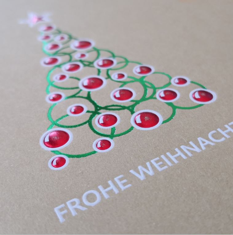 Detailansicht Folienprägung in grün und rot von Weihnachtsbaum auf naturbrauner Karte