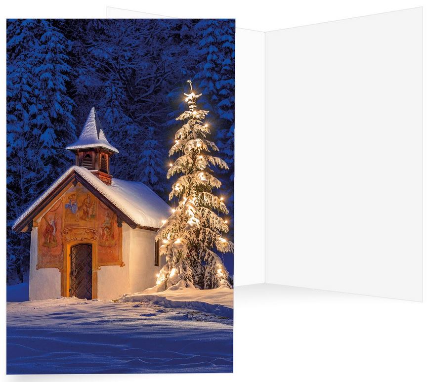 Winter-Weihnachtskarte mit kleiner Kapelle im Schnee vor verschneiten Tannen und leuchtendem Baum