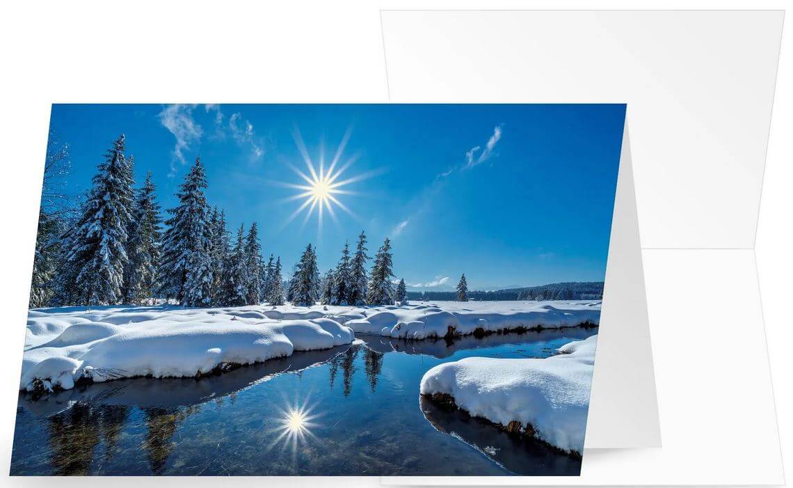 Winter-Weihnachtskarte in blau mit schneebedeckter Flusslandschaft und strahlender Sonne