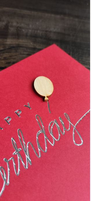 Detailansicht Luftballon aus echtem Holz und silberner Schriftzug "Happy Birthday" im Foliendruck