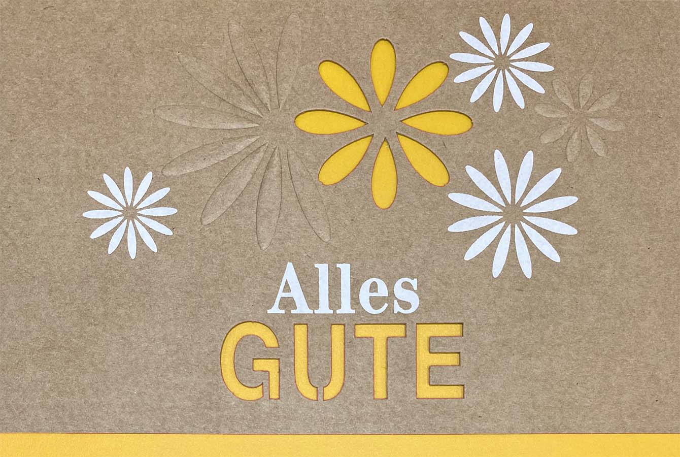 Naturbraune Glückwunschkarte mit Blüten und  "Alles Gute" sowie gelbem Einlegeblatt