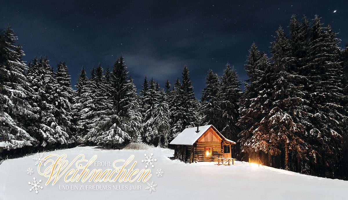 Weihnachtskarte mit verschneiter Berghütte am Wald und weihnachtlichen Grüßen