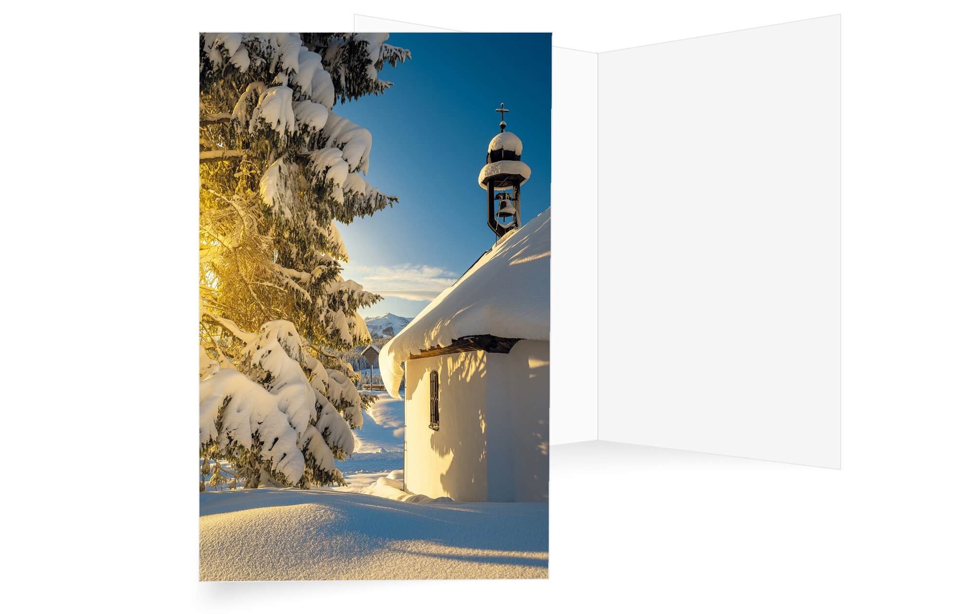 Winterliche Weihnachtskarte mit verschneiter Kapelle, Tannebaum und Berge im Hintergrund