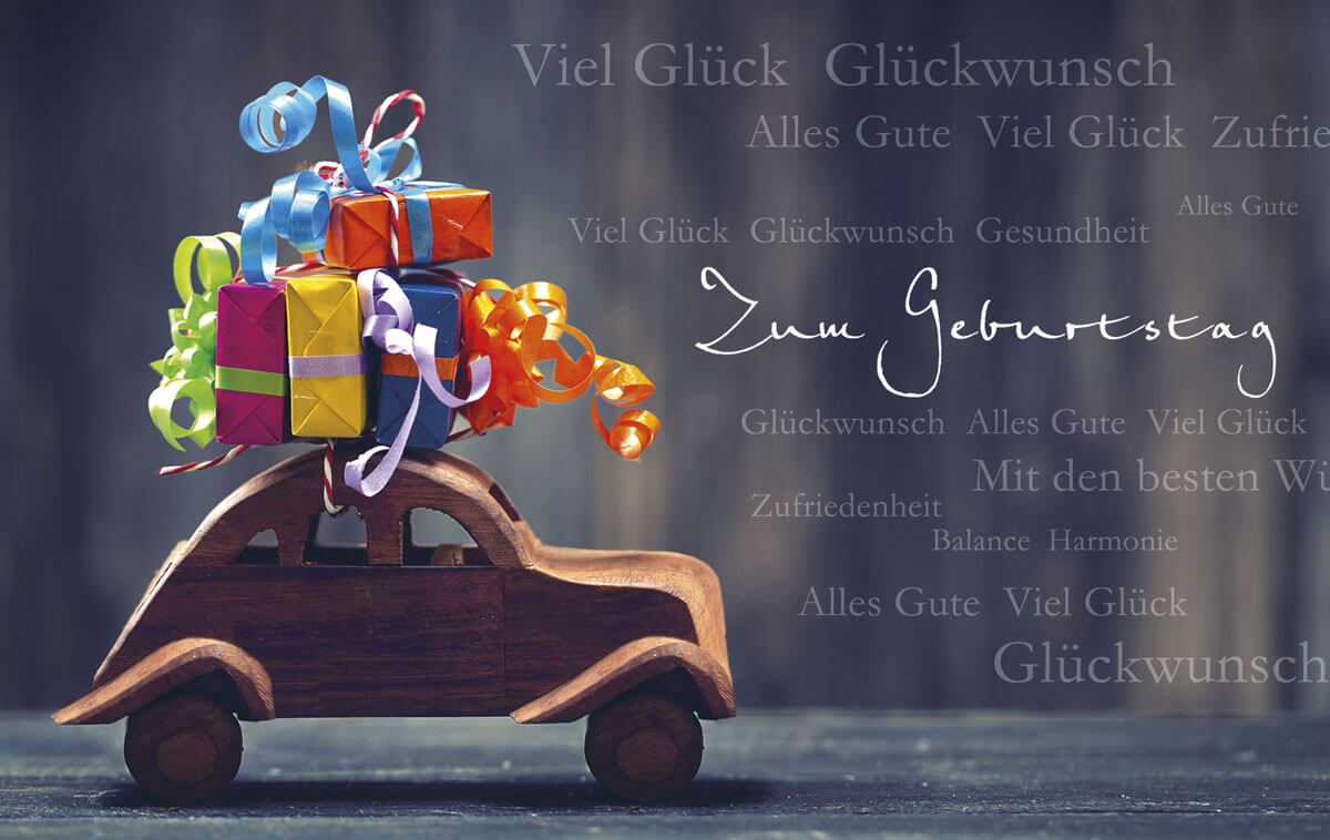 Originelle Glückwunschkarte zum Geburtstag mit kleinem Holzauto und bunten Geschenken