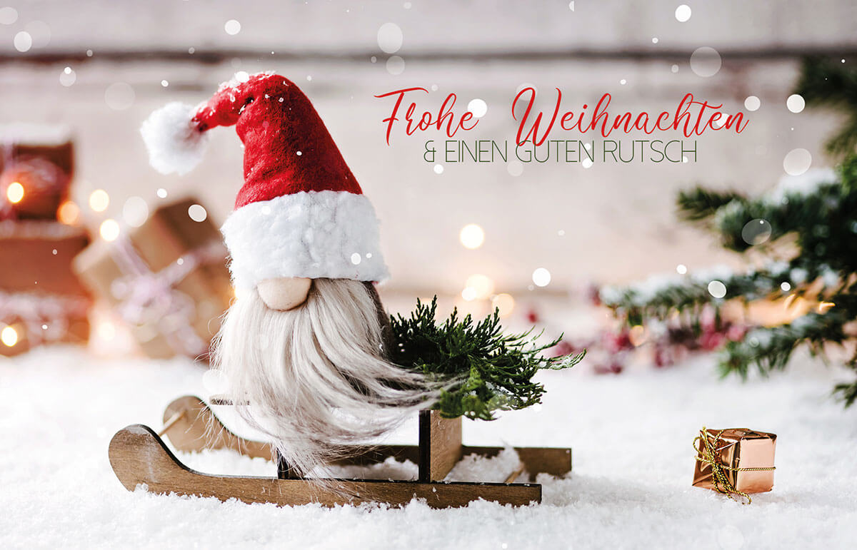 Lustige Weihnachtskarte mit kleinem Weihnachtswichtel auf Holzschlitten und Gruß