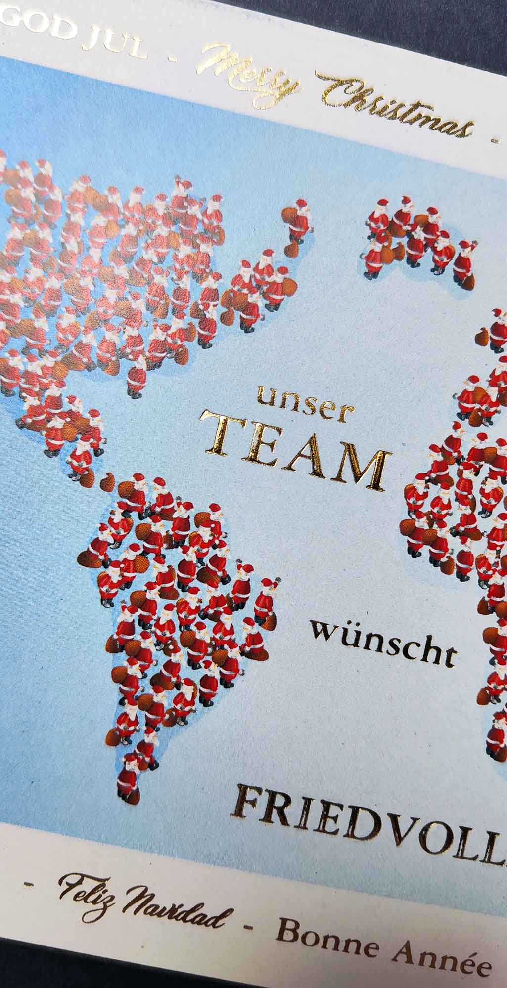 Detailansicht Weihnachtsmänner bilden Kontinente, Team-Weihnachtsgruß in gold geprägt