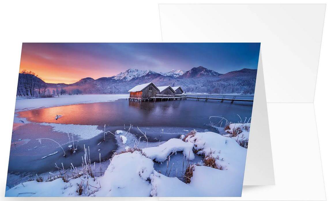 Stimmungsvolle Weihnachtskarte mit Berg- und Seenlandschaft im Licht des Abendrotes