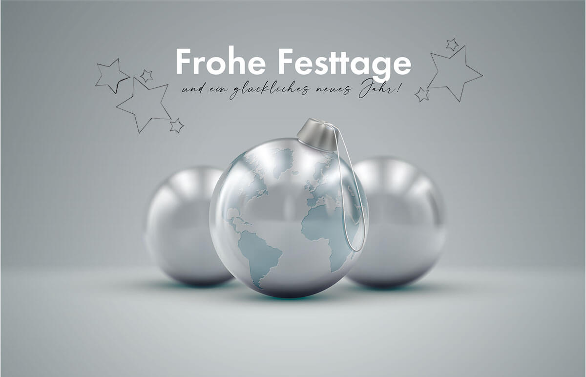 Weihnachtskarte mit drei silbernen Christbaumkugeln, einzelnen Kontinenten und Weihnachtsgruß