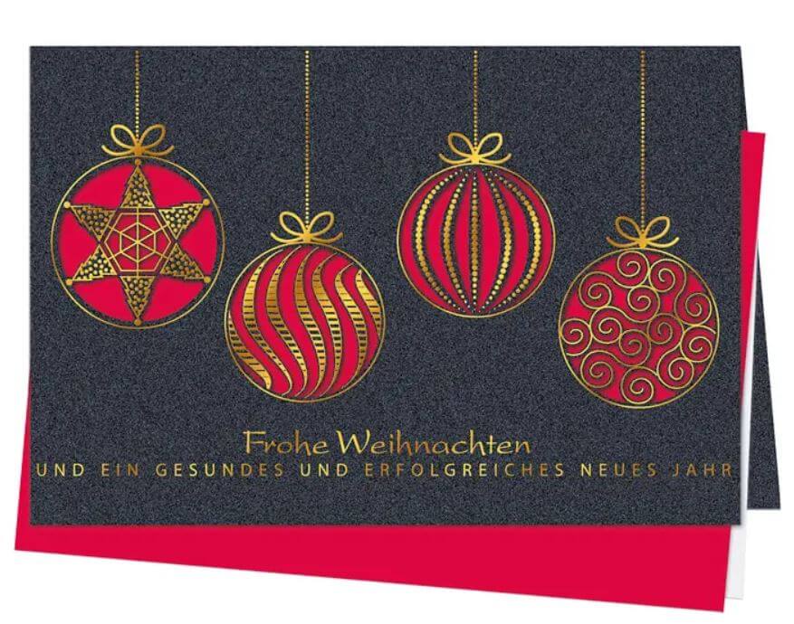 Anthrazitfarbene Weihnachtskarte mit filigran gelaserten Baumkugeln und rotem Falteinleger