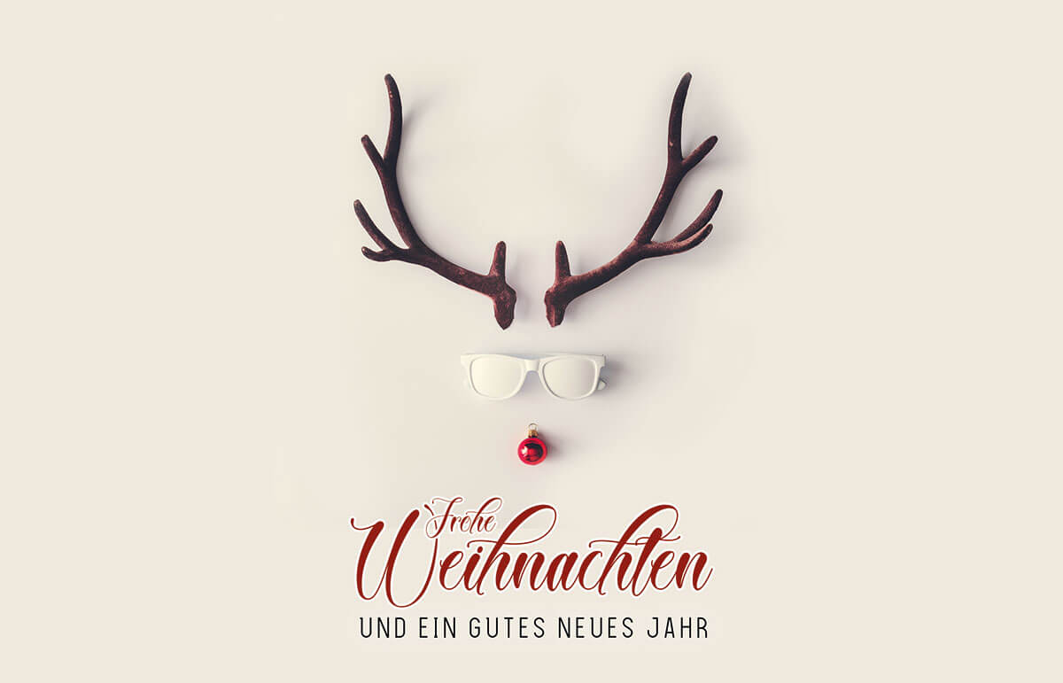 Humorvolle Weihnachtskarte mit Hirschkopf auf Geweih, Sonnenbrille und Baumkugel