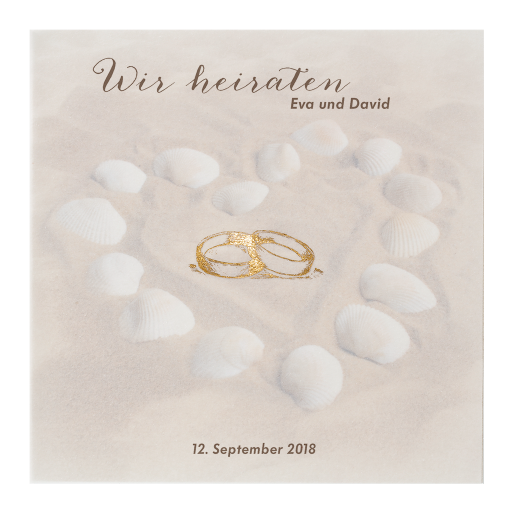 Hochzeitskarte mit Ringen und Herz aus Muscheln im Sandstrand