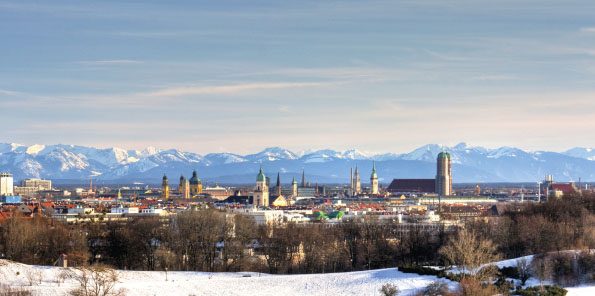 Weihnachtskarte mit winterlicher Stadtansicht von München und die Alpen im Hintergrund