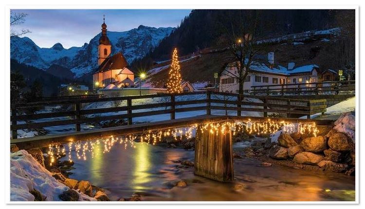 Winter-Weihnachtskarte im kleinen Format mit leuchtender Holzbrücke, Kirche und verschneiten Bergen