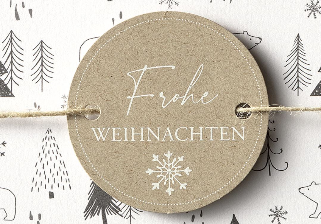 Detailansicht runder Anhänger aus Naturkarton mit weißem Gruß "Frohe Weihnachten".