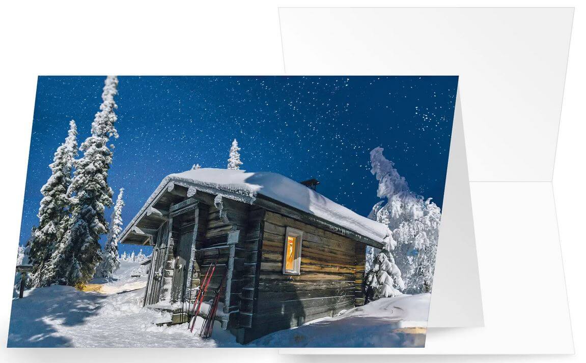 Winterliche Weihnachtskarte mit verschneiter Berghütte bei blauem Himmel, ohne Gruß